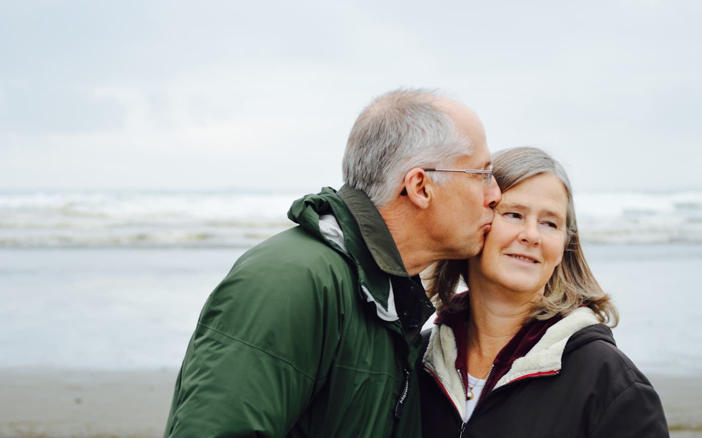 Un couple de retraités souriants, au bord de la mer